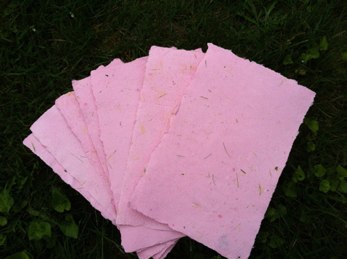 sheets of handmade pink paper recycled from used copier paper scraps