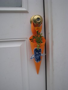 marigold flower in a paper cone hung on a doorknob